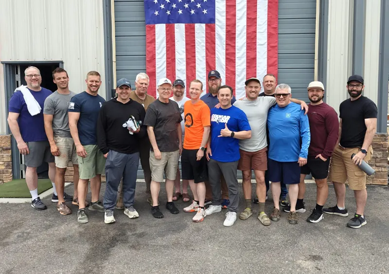 Retreat 01 attendees standing together in front of an American flag