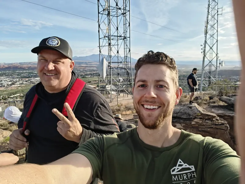 Two FSD members grinning on the summit at sunrise during the retreat hike