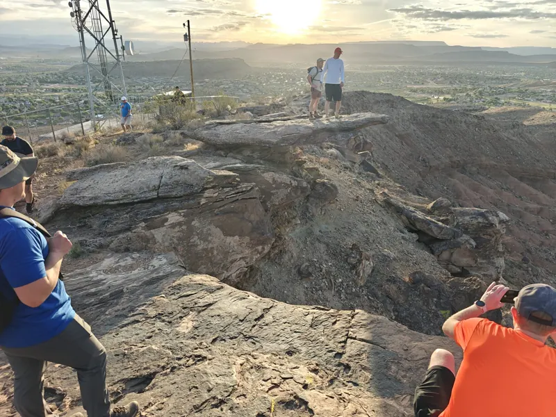 Retreat attendees on a ridge at sunrise above St. George, Utah
